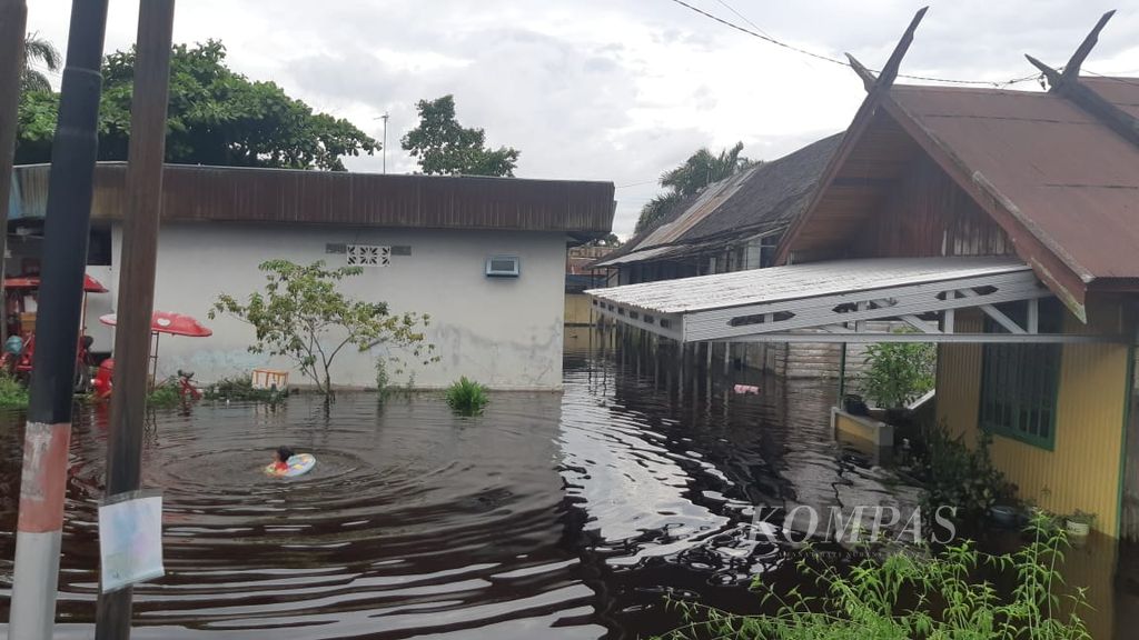 Seorang anak berendam di tengah banjir di Jalan Arut, Kota Palangkaraya, Kalimantan Tengah, Minggu (10/3/2024). Setidaknya lima kabupaten di Kalteng terendam banjir akibat luapan sungai.