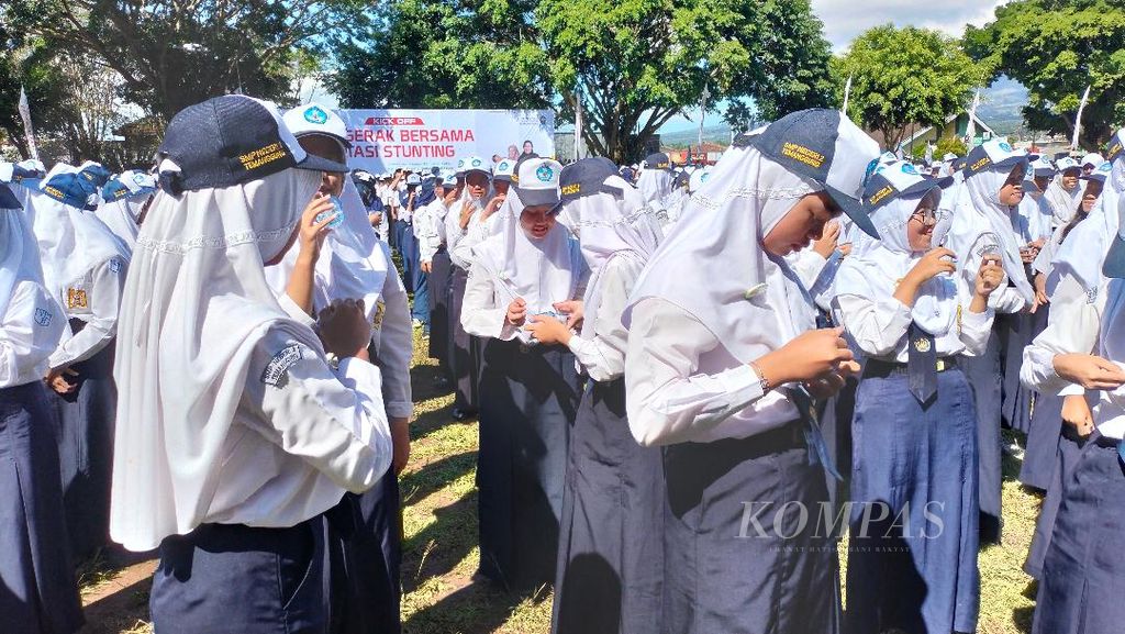 Sejumlah siswi SMP bersama-sama meminum pil tambah darah dalam acara <i>kick off</i> gerakan bersama mengatasi tengkes di Alun-alun Temanggung, Jumat (12/5/2023).