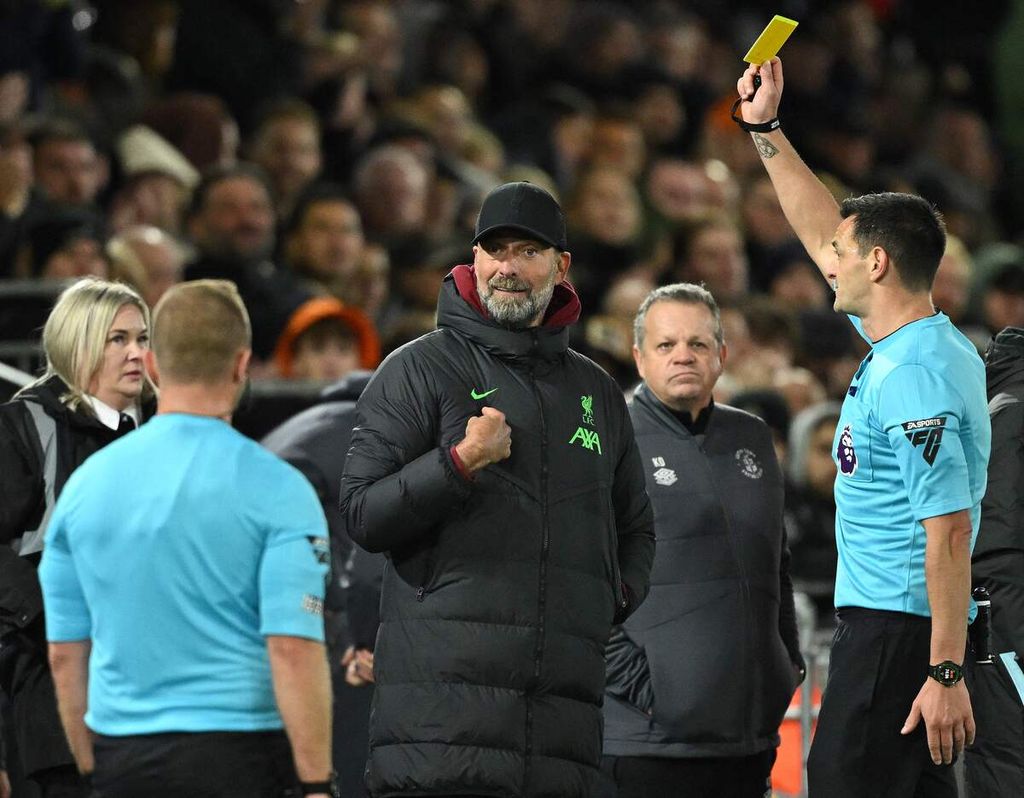 Wasit Andy Madley (kanan) memberi kartu kuning kepada Manajer Liverpool Jurgen Klopp saat laga Liverpool lawan Luton, Senin (6/11/2023) dini hari WIB. 