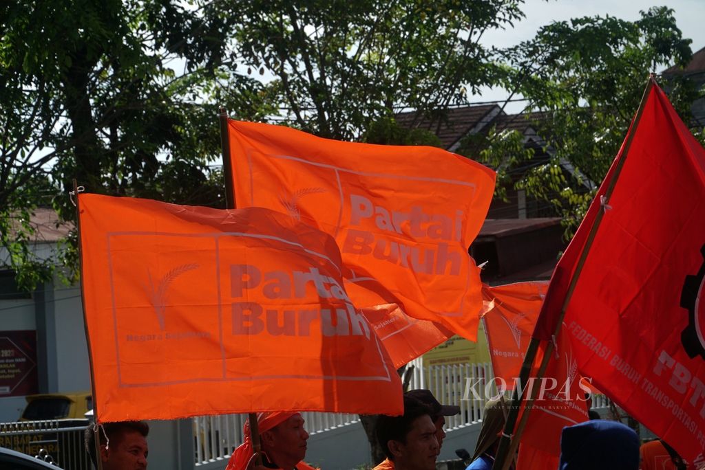 Bendera Partai Buruh berkibar dalam aksi peringatan Hari Buruh Internasional yang digelar anggota Partai Buruh dan serikat pekerja di depan Kantor DPRD Sumatera Barat di Kota Padang, Senin (1/5/2023) sore.