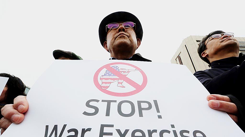 Pengunjuk rasa di Seoul, Korea Selatan, Rabu (21/3), memegang poster yang berisi seruan agar latihan perang gabungan tahunan Korsel-Amerika Serikat dibatalkan. Unjuk rasa berlangsung di dekat Kedutaan Besar AS. Latihan perang Korsel-AS direncanakan berlangsung pada 1 April. 