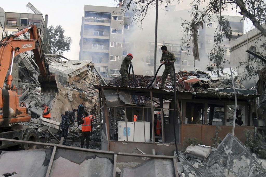 Dalam foto yang dirilis Kantor Berita Suriah (SANA) terlihat petugas penyelamat tengah menyingkirkan reruntuhan bangunan yang hancur akibat serangan udara Israel di Damaskus, Suriah, Senin (1/4/2024) waktu setempat.