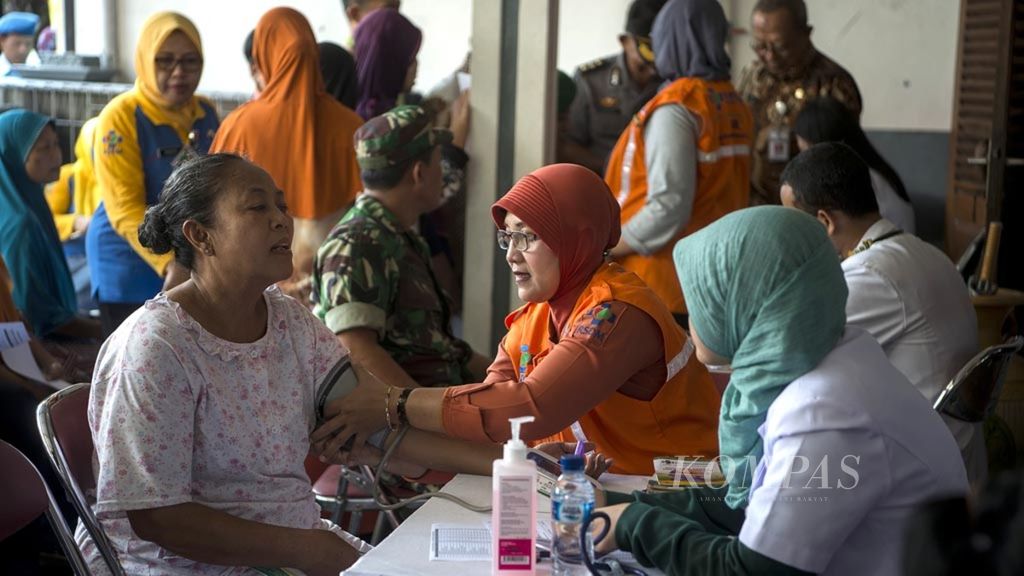 Petugas medis dari Rumah Sakit Umum Daerah Dr Moewardi memberikan layanan pengobatan gratis dan penyuluhan tentang penyakit stroke bagi warga di Kampung Mondokan, Jebres, Solo, Jawa Tengah, Selasa (30/10/2018). 