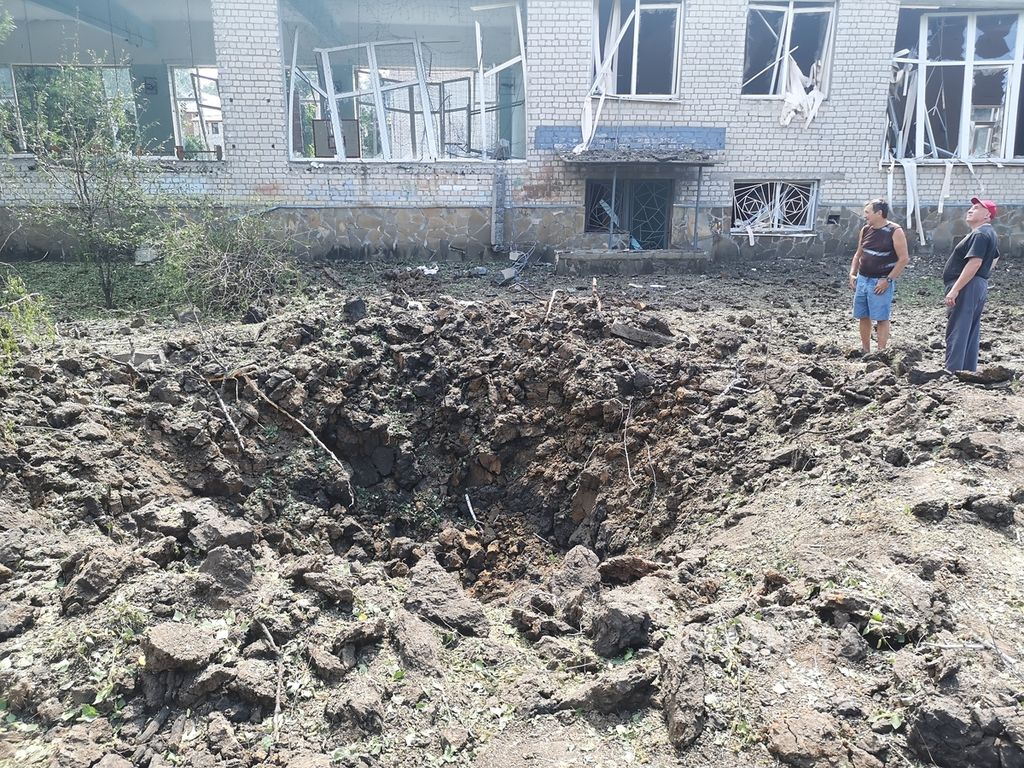Lubang bekas bom di halaman belakang sekolah yang hancur dihantam rudal Rusia di Distrik Shevchenkivskiy Kharkiv, Ukraina, Senin (4/7/2022). Dua rudal mengenai sekolah ini pada Senin pukul 04.00 waktu setempat.