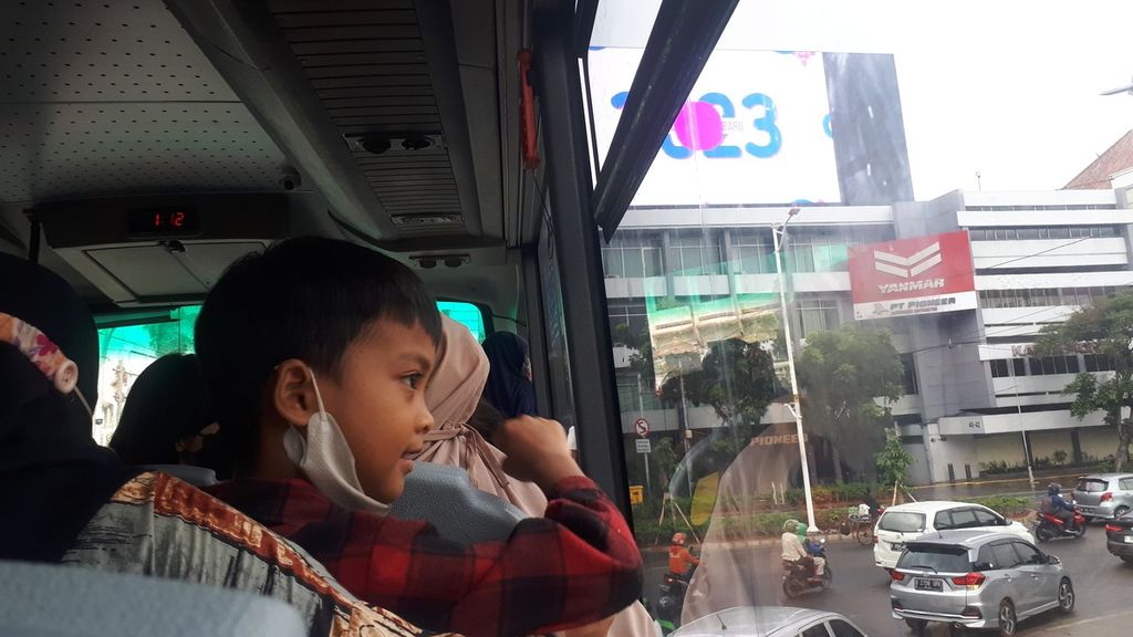 Seorang anak menikmati pemandangan Jakarta dari atas dek bus wisata Transjakarta jalur BW 2 dari Halte IRTI Monas menuju Halte Masjid Istiqlal, Jumat (30/12/2022).