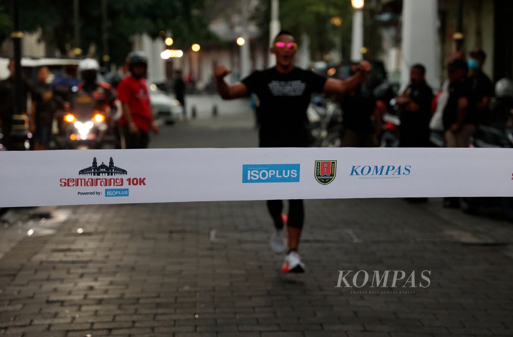 Salah satu pelari menuju garis finis saat mengikuti acara lari sore dalam rangka peluncuran jersey dan medali Semarang 10K di Kota Lama, Kota Semarang, Jawa Tengah, Sabtu (3/12/2022).