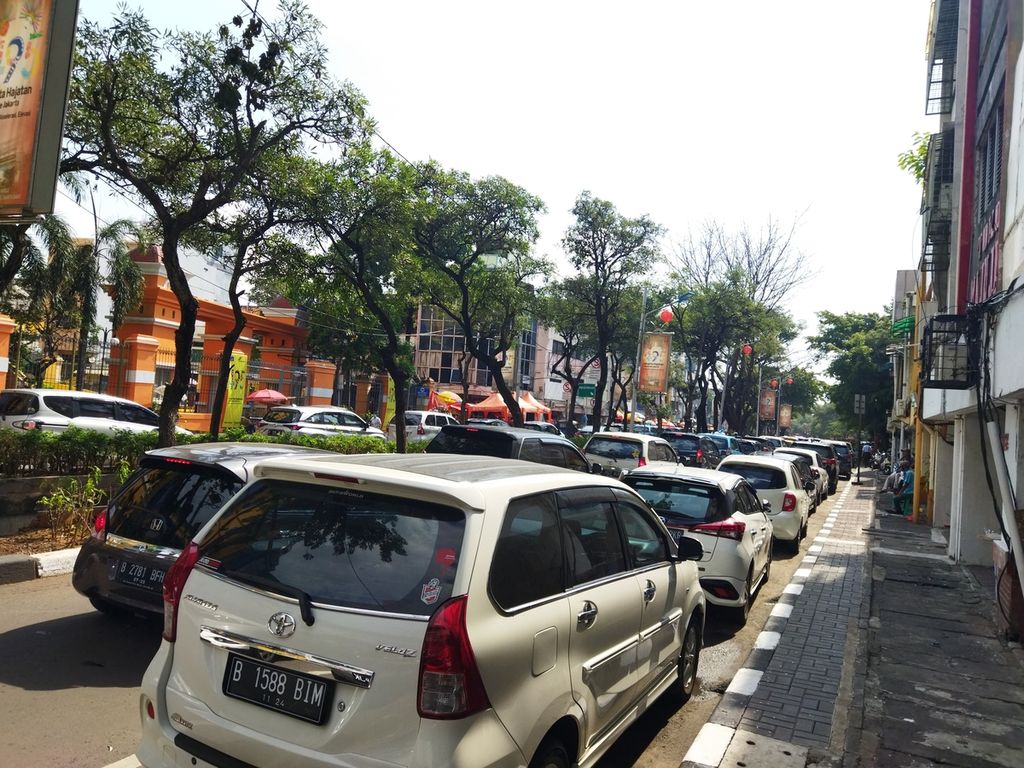 Mobil parkir di bahu Jalan Pancoran menyebabkan antrean panjang di kawasan pecinan Pancoran, Glodok, Jakarta Barat, Minggu (3/7/2022).