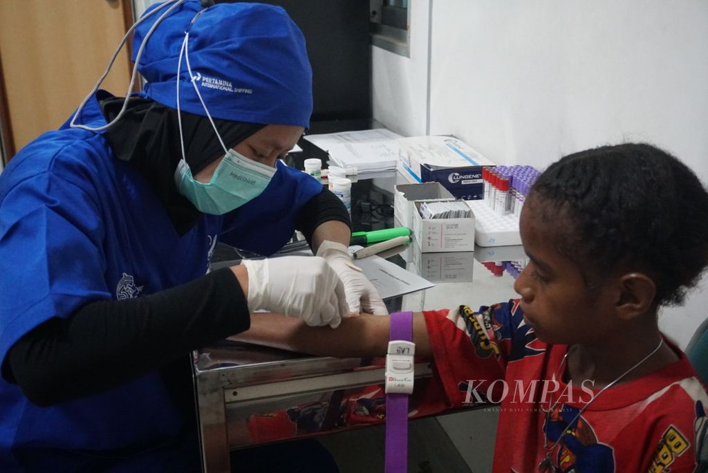 Maira (10) sedang diambil darahnya sebagai sampel pemeriksaan terhadap tumor yang dialaminya. Pemeriksaan laboratorium menjadi salah satu layanan yang diberikan di Rumah Sakit Apung Nusa Waluya 2 di dermaga di Distrik Seget, Sorong, Papua Barat Daya, Kamis (7/12/2023). 