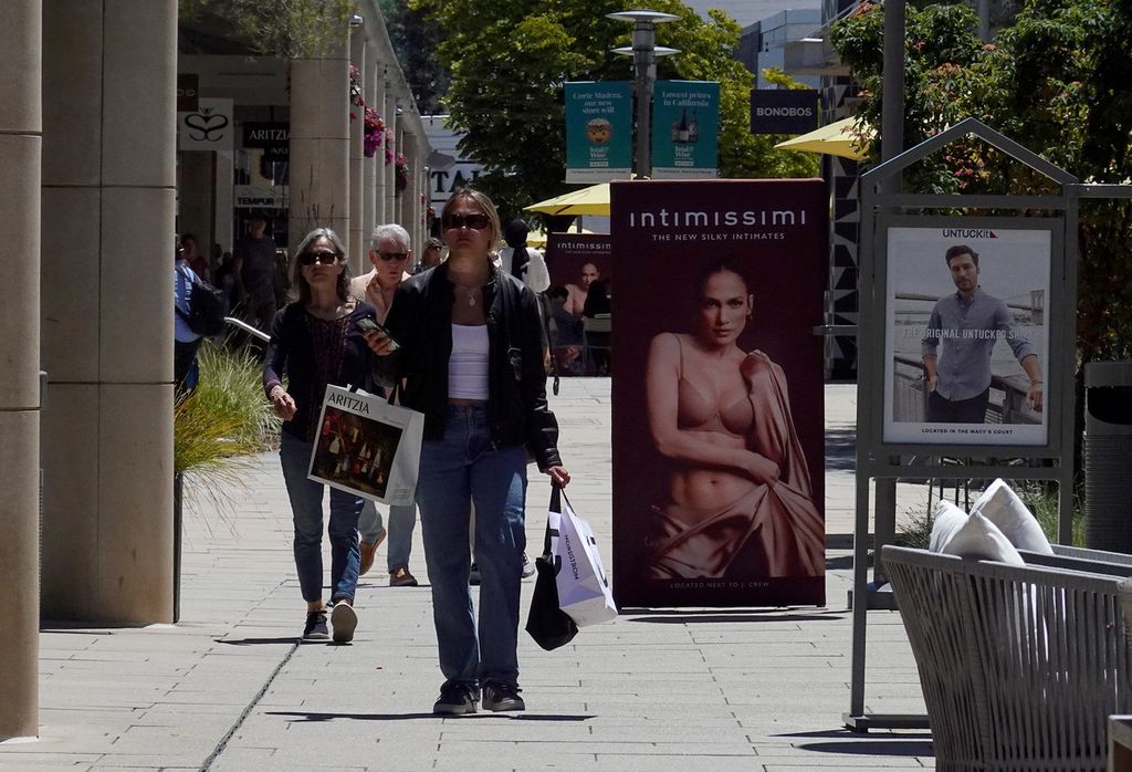 A shopper carries shopping bags while walking through The Village on May 30, 2024 in Corte Madera, California, USA. 