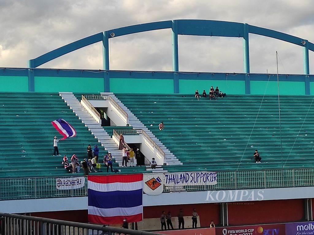 Pendukung Thailand mengibarkan bendera Thailand pada laga Grup B Piala AFF U-16 2022 melawan Timor Leste, Minggu (7/8/2022), di Stadion Maguwoharjo, Sleman, Daerah Istimewa Yogyakarta. Dukungan suporter membantu "Gajah Perang" menumbangkan Timor Leste 4-1.