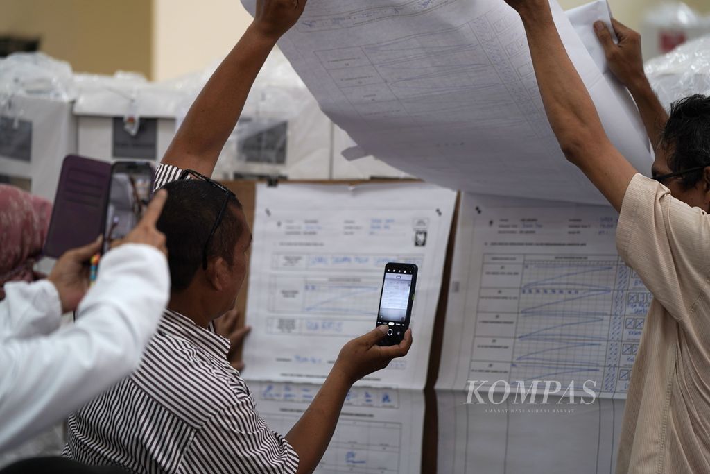 Saksi mengabadikan hasil penghitungan suara TPS dalam rekapitulasi hasil penghitungan suara tingkat kecamatan di GOR Duren Sawit, Jakarta Timur, Sabtu (17/2/2024). Proses rekapitulasi hasil penghitungan perolehan suara untuk Pemilu 2024 dilakukan setelah proses penghitungan suara selesai mulai Kamis (15/2/2024) hingga Rabu (20/3/2024). 