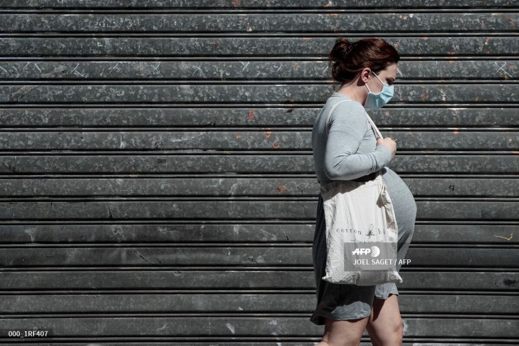 Seorang perempuan hamil berjalan di Paris, Perancis, 13 Mei 2020.