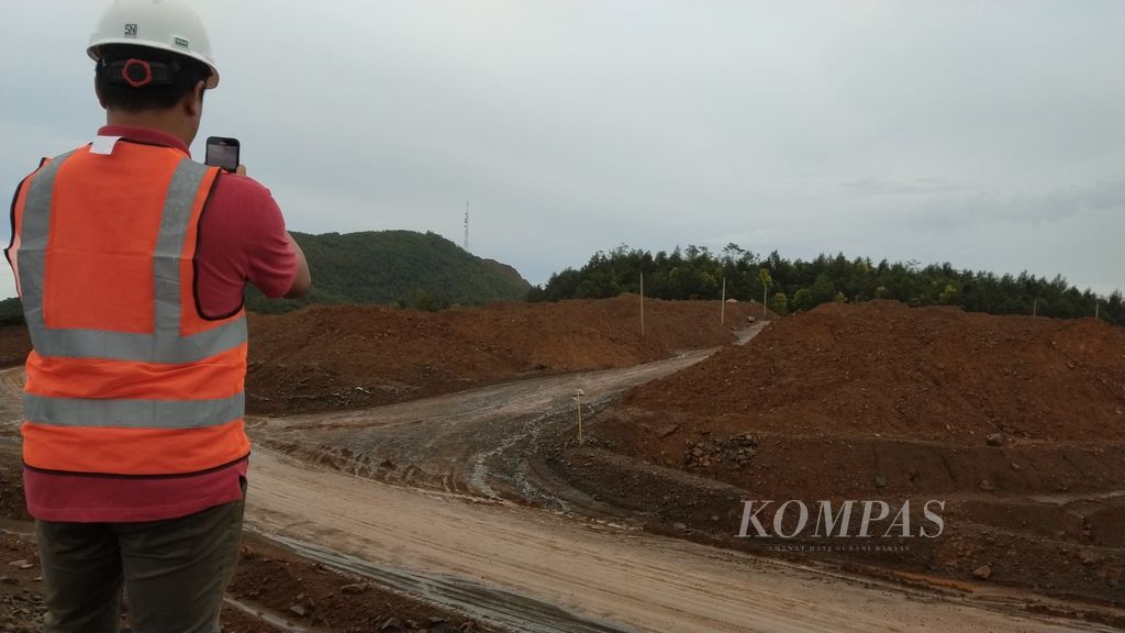 Wartawan memotret tumpukan bijih (ore) nikel di kompleks penambangan PT Trimegah Bangun Persada, bagian dari grup Harita Nickel, di Pulau Obi, Kabupaten Halmahera Selatan, Maluku Utara, Sabtu (8/4/2023).
