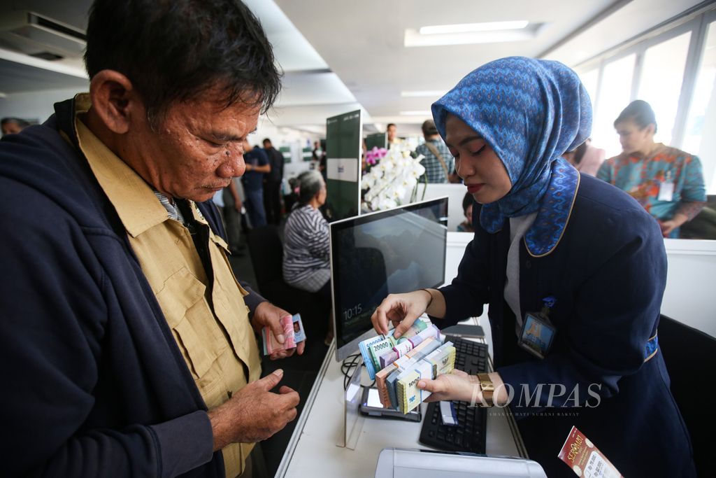 Petugas dari Bank BTN melayani penukaran uang di layanan kas keliling terpadu yang diselenggarakan Bank Indonesia bersama perbankan di Istora Senayan, Jakarta, Kamis (28/3/2024).