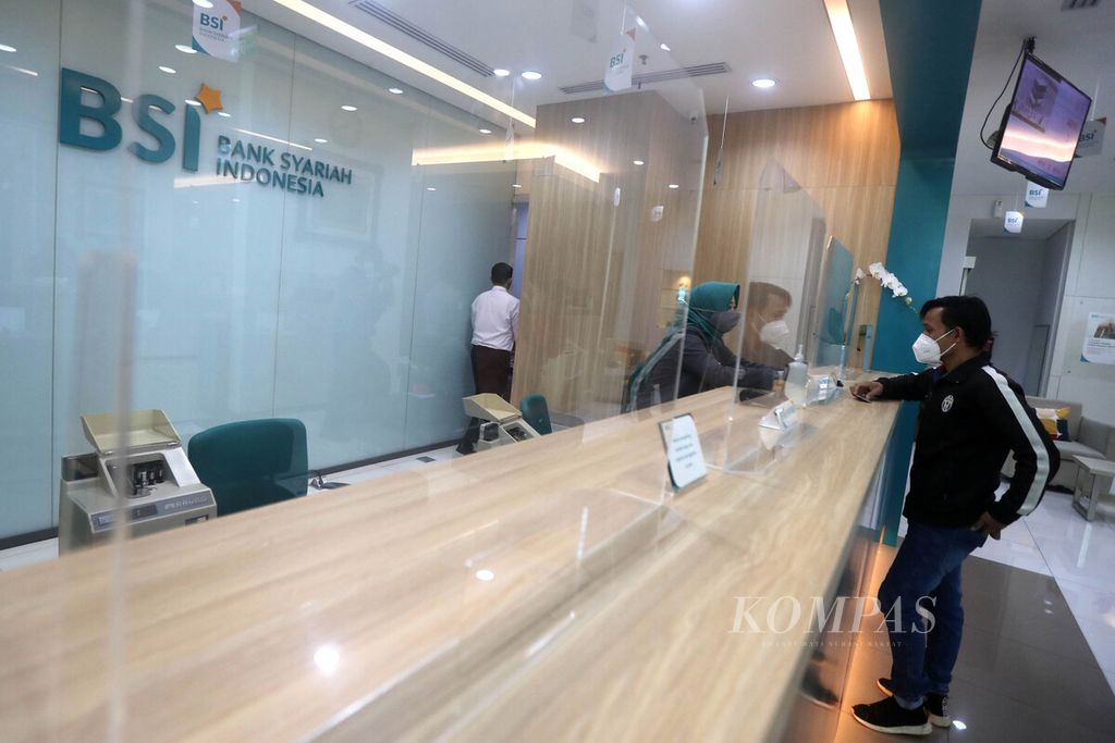 Teller Bank Syariah Indonesia melayani nasabah di Kantor Cabang Hasanudin, Blok M, Jakarta, Senin (1/2/2021). Bank yang merupakan hasil merger dari PT Bank BRI Syariah Tbk, PT Bank BNI Syariah, dan PT Bank Syariah Mandiri tersebut resmi beroperasi pada Senin (1/2/2021). 
