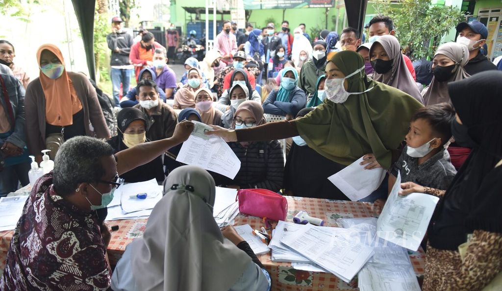 Warga mendapatkan nomor antrean untuk mengikuti vaksinasi penguat di Puskesmas Ganting, Kecamatan Gedangan, Kabupaten Sidoarjo, Jawa Timur, Selasa (29/3/2022). Pemberlakuan syarat sudah vaksin ketiga atau penguat untuk mudik Lebaran membuat banyak warga berbondong-bondong ke sejumlah sentra vaksin Covid-19. 