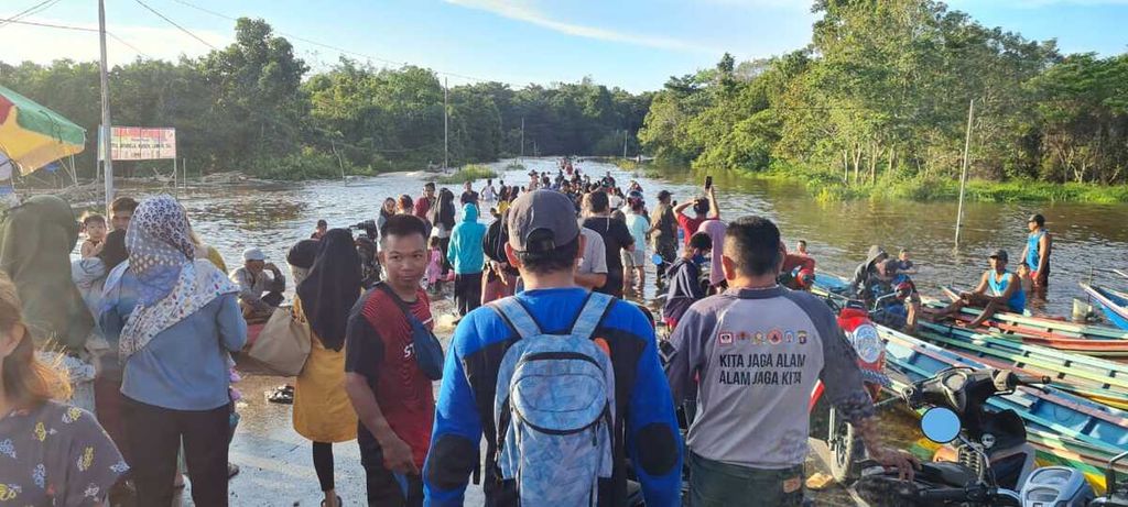 Petugas membantu masyarakat melintasi banjir menggunakan perahu karet di Kabupaten Murung Raya, Kalimantan Tengah, Senin (23/5/2022). Banjir di wilayah tersebut berdampak ke enam kecamatan.