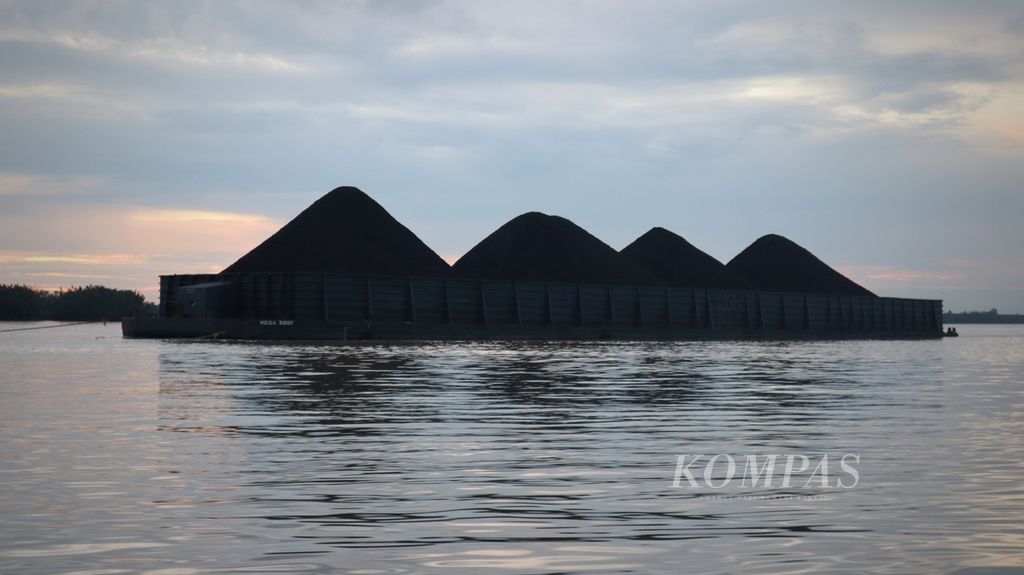 Kapal tongkang terisi penuh batubara melintasi di Sungai Mahakam, wilayah Kelurahan Muara Kembang, Kecamatan Muara Jawa, Kutai Kartanegara, Kalimantan Timur, pada Senin (4/7/2022) sore.