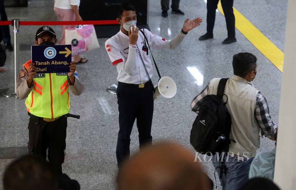 Petugas mengarahkan calon penumpang KRL Commuter Line dengan pelantang di apron atas Stasiun Manggarai, Jakarta Selatan, Senin (30/5/2022). 