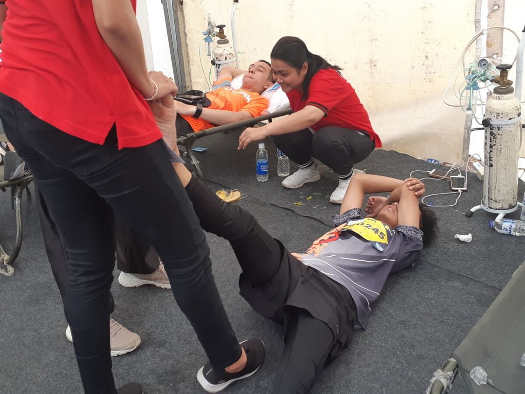 Ravhie Walimaher (21) mendapat perawatan medis di posko kesehatan Electrik Jakarta Marathon, Minggu (28/10/2018). Ia menahan sakit karena mengalami keram. Kewaspadaan perlu ditingkatkan apabila sering mengalami keram karena bisa menjadi tanda dari penyakit arteri perifer.
