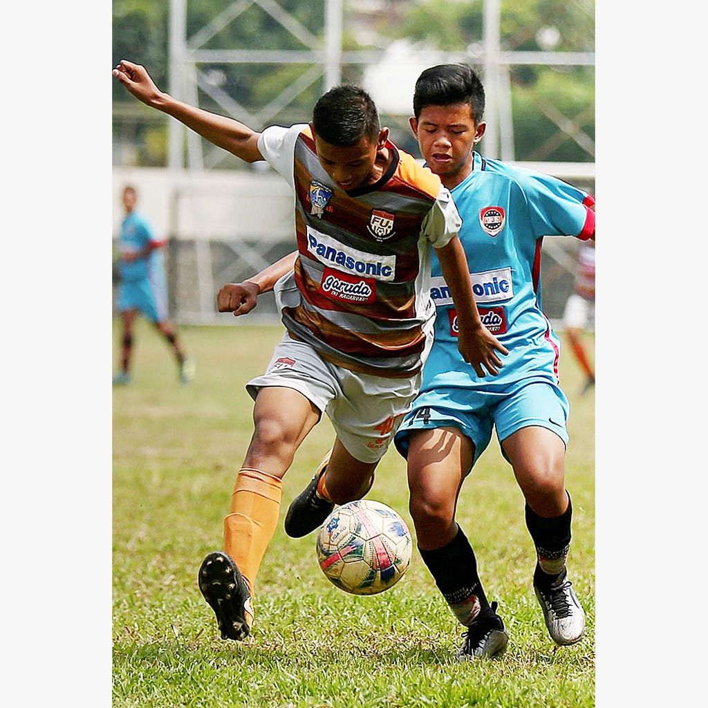 Pemain SSB Mandiri Selection SS Muhammad Afif Fathoni (biru) berebut bola dengan pemain SSB Talenta Muda FU 15 Syaeful Hardiyansyah pada laga Liga Kompas Gramedia Panasonic U-14 di Stadion GOR Ciracas, Jakarta Timur, Minggu (5/11). Pertandingan berakhir imbang dengan skor 1-1. 