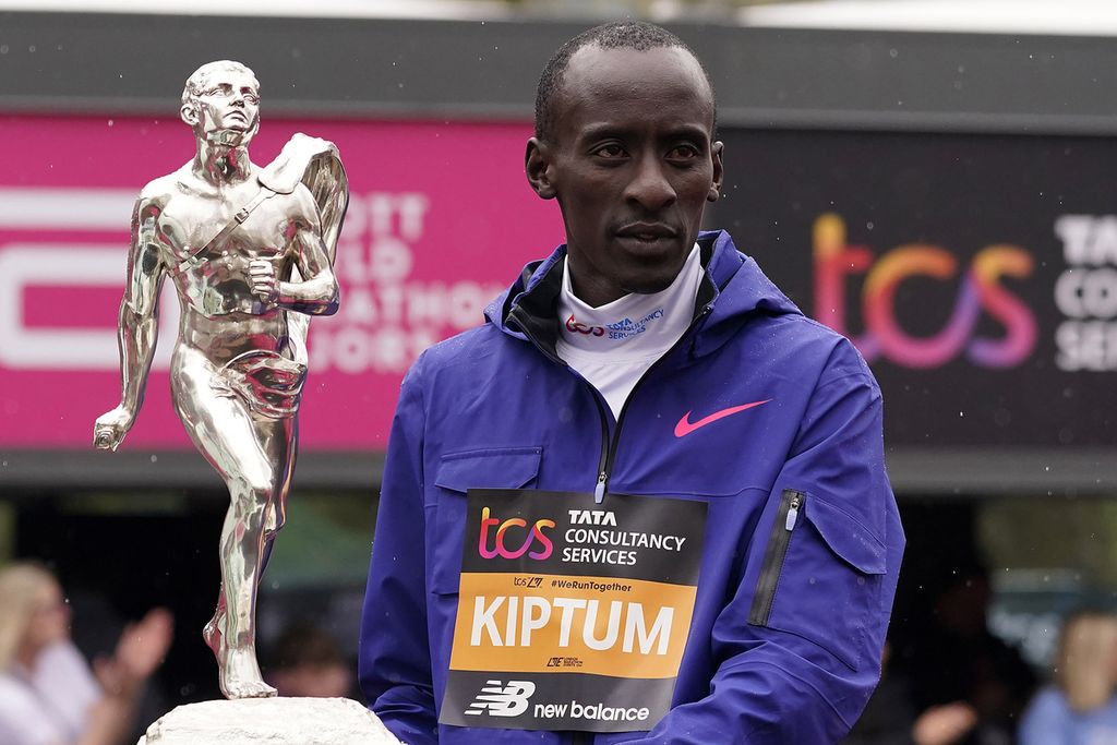 Pelari Kenya Kelvin Kiptum memegang trofi seusai Maraton Chicago 2023 dengan catatan waktu 2 jam 35 detik, yang menjadi rekor dunia, pada 8 Oktober 2023. Kiptum meninggal dalam kecelakaan mobil di Kenya, Senin (12/2/2024) dini hari WIB. 