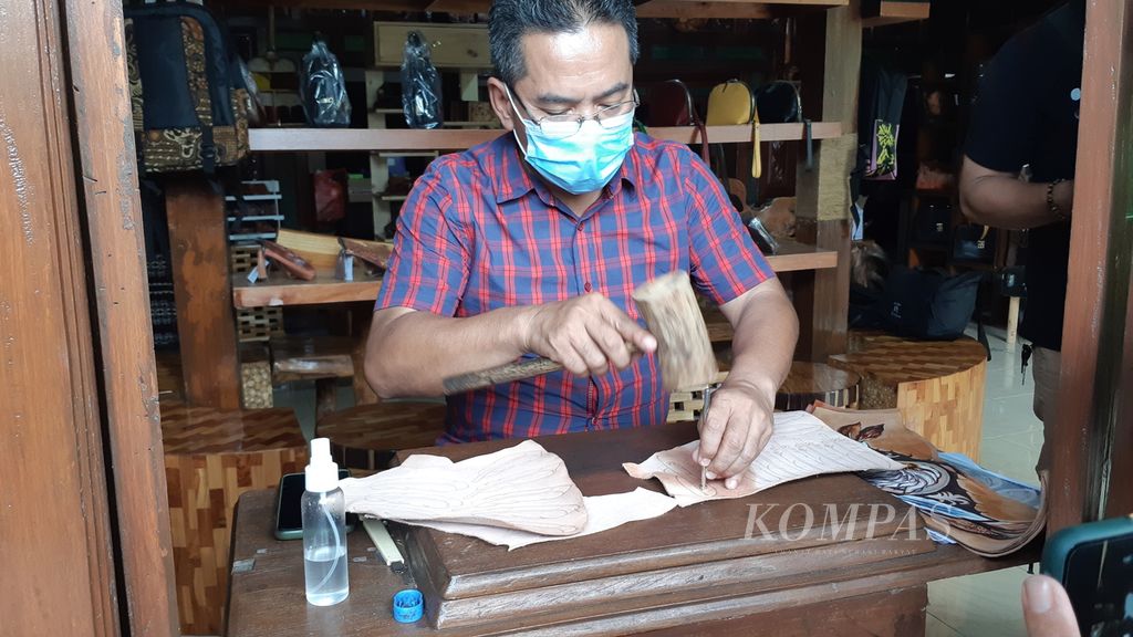 Perajin tas koper kulit Tanggulangin, Makhbub Junaidi, menunjukkan produknya, Rabu (8/12/2021), di Sidoarjo, Jawa Timur. Perajin tas kulit menikmati kredit dengan bunga ringan untuk membangkitkan usahanya yang terdampak pandemi.