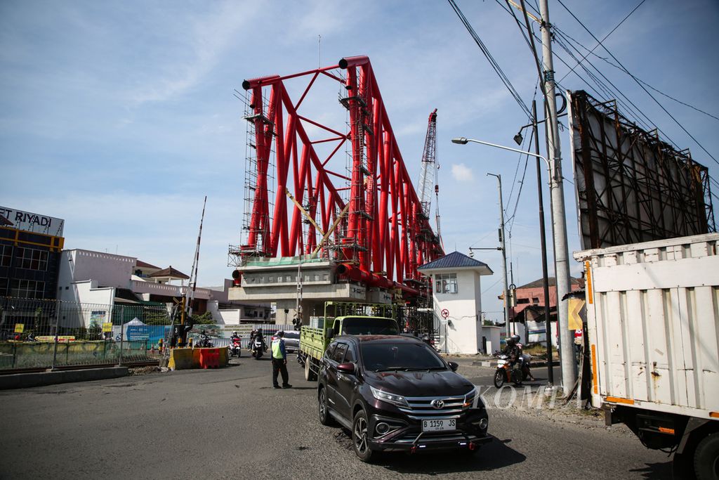 Kendaraan melintas di dekat proyek pembangunan jalur ganda rel layang di Simpang Joglo, Solo, Jawa Tengah, Jumat (14/7/2023). Jalur kereta di Simpang Joglo ini memiliki frekuensi pergerakan kereta api yang cukup padat.