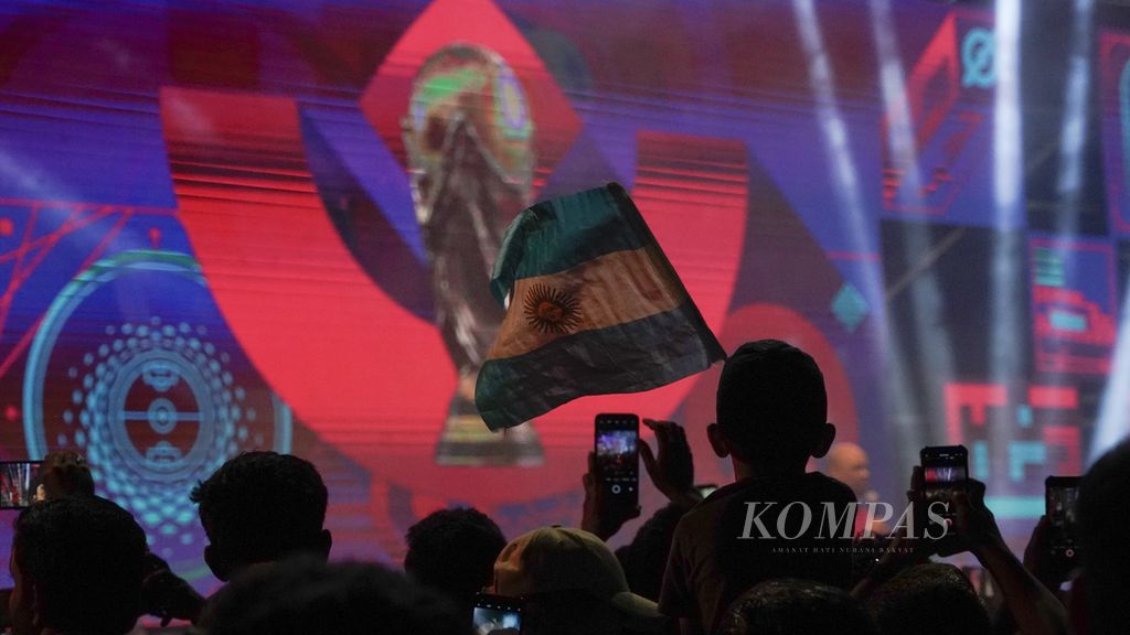 Seorang anak mengibarkan bendera Argentina dalam acara tur trofi Piala Dunia yang dipamerkan di Aspire Park, Doha, Qatar, Selasa (15/11/2022). Ajang ini menjadi penyemarak menjelang diselenggarakan turnamen Piala Dunia 2022 yang akan berlangsung 20 November - 18 Desember 2022. 