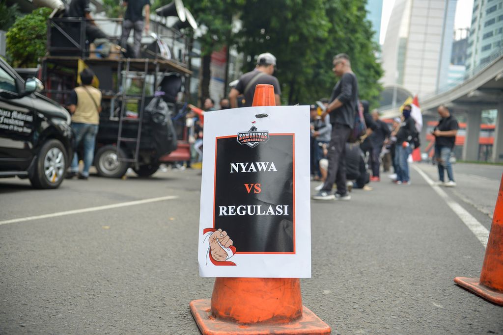 Poster tuntutan peserta aksi ditempel di <i>traffic cone</i> di depan Kantor Kementerian Kesehatan (Kemenkes), Jakarta Pusat, Senin (29/5/2023). 