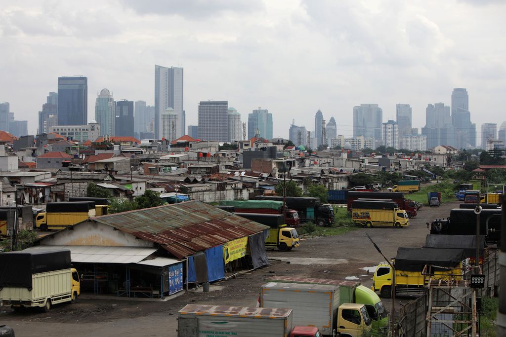 Perkampungan padat penduduk dengan latar belakang gedung bertingkat di Jakarta, Jumat (23/12/2022). Pemerintah akan melanjutkan program perlindungan sosial untuk mendorong tingkat kemiskinan pada 2023 menurun di kisaran 7,5-8,5 persen, tingkat pengangguran terbuka sekitar 5,3-6,0 persen, dan perbaikan ketimpangan (gini ratio) menjadi 0,375-0,378.
