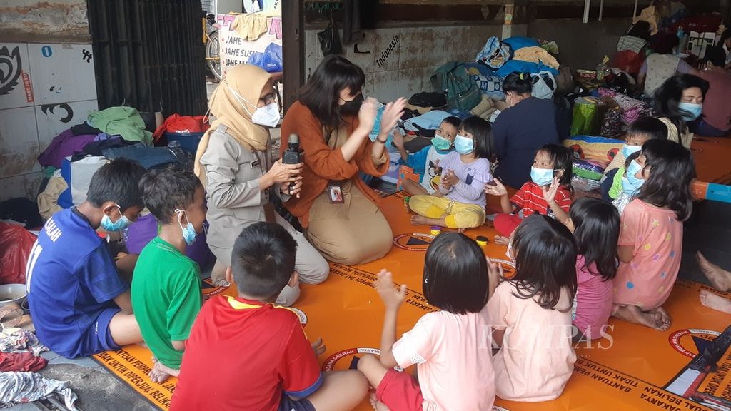 Petugas layanan psikososial Sudin Sosial Jakarta Pusat mengajak bermain anak-anak korban kebakaran di lingkungan RW 009 Kelurahan Mangga Dua Selatan, Kecamatan Sawah Besar, Jakarta Pusat, Senin (31/1/2022).