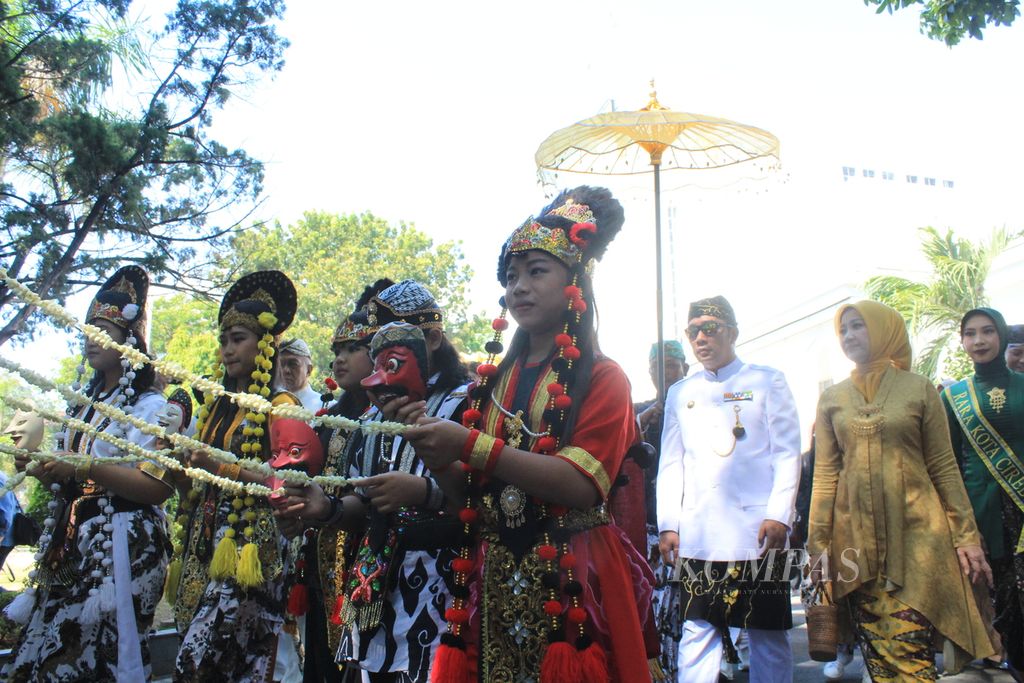 Rombongan penari mengantar Gubernur Jawa Barat Ridwan Kamil (pakaian putih) bersama istrinya, Atalia Praratya (pakaian kuning), menuju kantor DPRD Kota Cirebon dalam rangkaian Hari Jadi Ke-654 Tahun Kota Cirebon, Rabu (19/7/2023). 