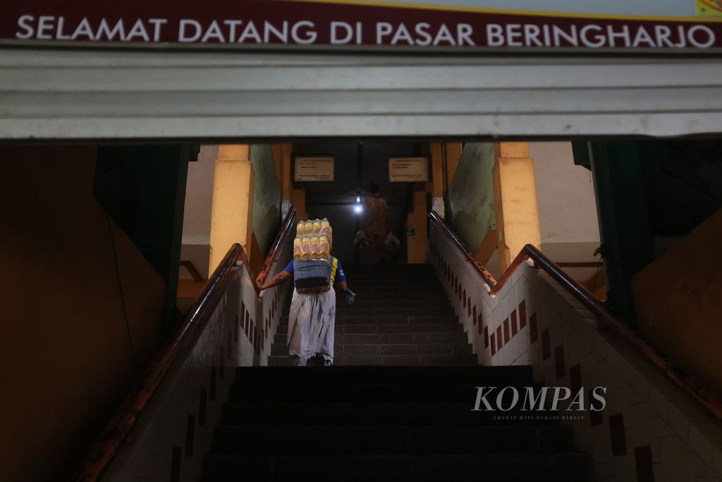 Buruh gendong memindahkan minyak goreng Minyakita yang didistribusikan di Pasar Beringharjo, Yogyakarta, Kamis (16/2/2023). 