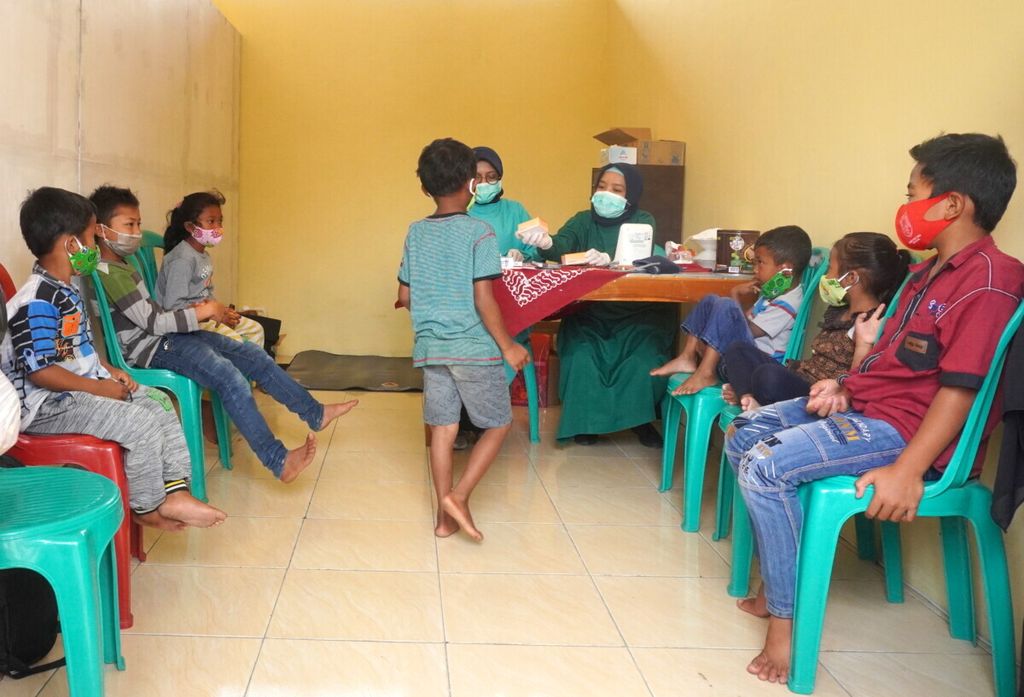 Anak-anak pengungsi mendapatkan obat flu seusai memeriksakan diri di pengungsian Balai Desa Deyangan, Kecamatan Mertoyudan, Kabupaten Magelang, Jawa  Tengah, November 2020.