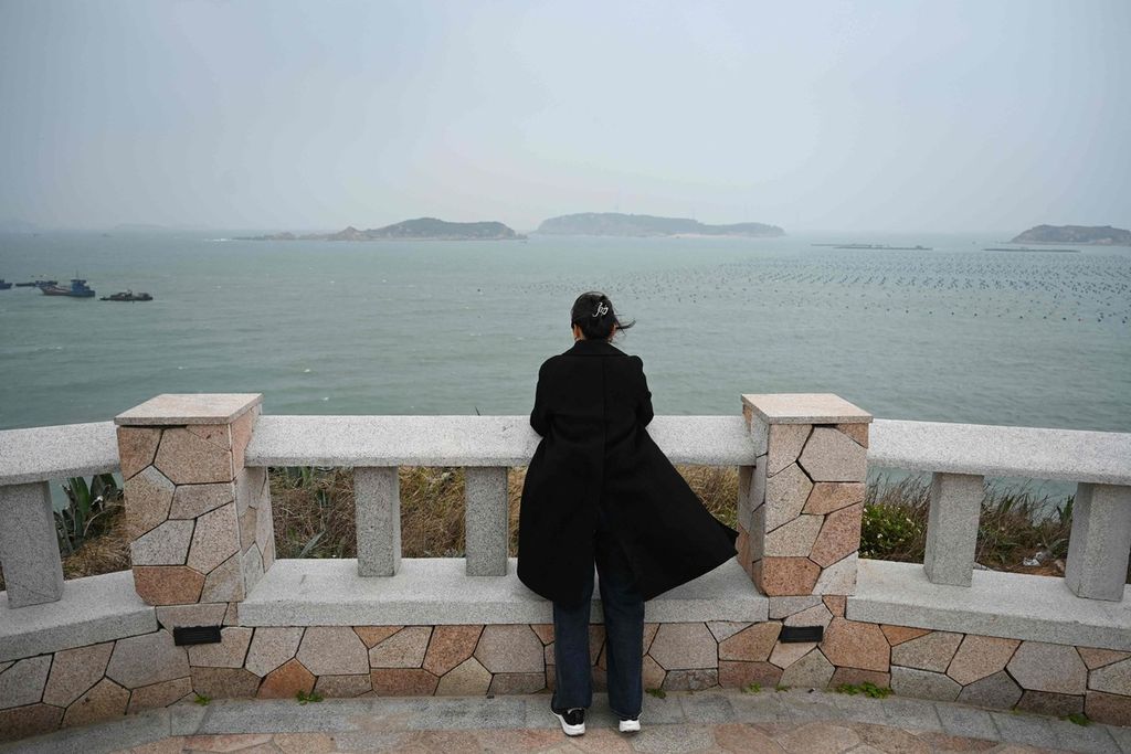 Seorang perempuan memandang ke Selat Taiwan dari Pulau Pingtan, China, titik terdekat dengan daratan Taiwan, Senin (15/1/2024). 