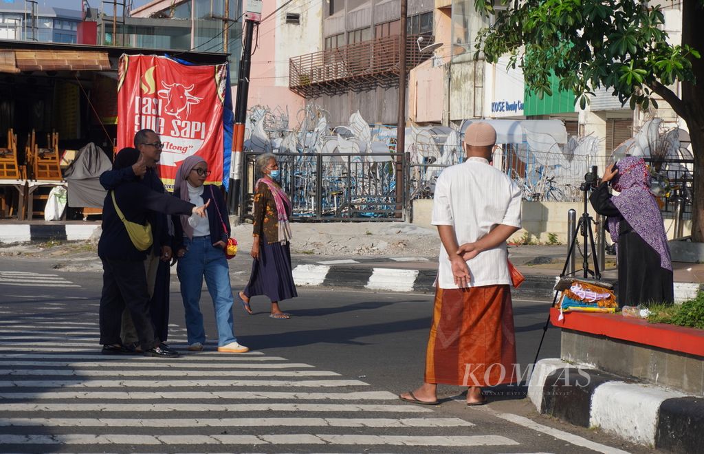 Pemudik berfoto usai menjalani shalat Idul Fitri di Lapangan Simpang Lima, Kota Semarang, Jawa Tengah, Senin (2/5/2022). Kegiatan itu diikuti ribuan umat Islam dari Kota Semarang dan sekitarnya.