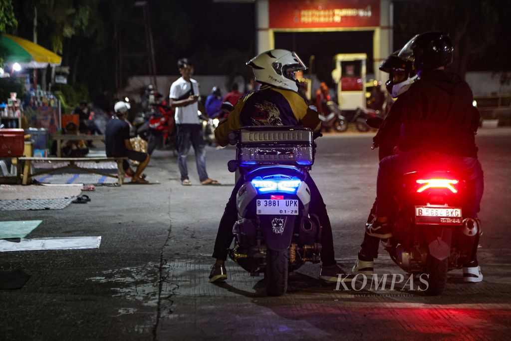 Pemudik sepeda motor berbincang saat berhenti di salah satu SPBU di Jalan Raya Pantura, Karawang, Jawa Barat, Minggu (7/4/2024). 