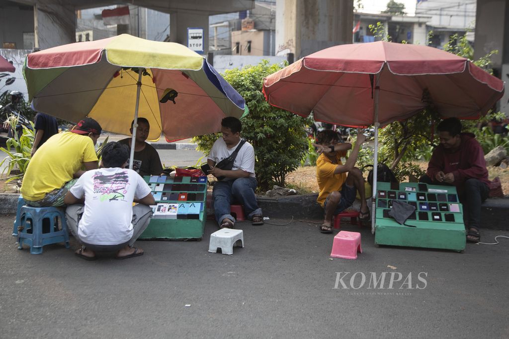 Pedagang ponsel bekas bertransaksi di kawasan Kebayoran Lama, Jakarta.