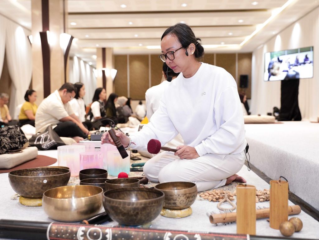 Deece dan Daya (duduk dibelakang Deece) sedang memainkan bermacam alat musik di kelas sound healing yang diikuti awak media di mal Plaza Indonesia Jakarta, Kamis (18/7/2024). Acara itu diadakan untuk mengawali Festival Wellness 2024 di mal tersebut.