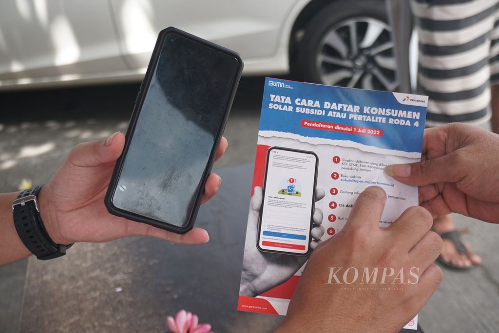 Petugas di gerai informasi MyPertamina memberi petunjuk pendaftaran diri kepada pengguna pertalite dan biosolar, Jumat (1/7/2022), di SPBU Politeknik, Kairagi, Manado, Sulawesi Utara.