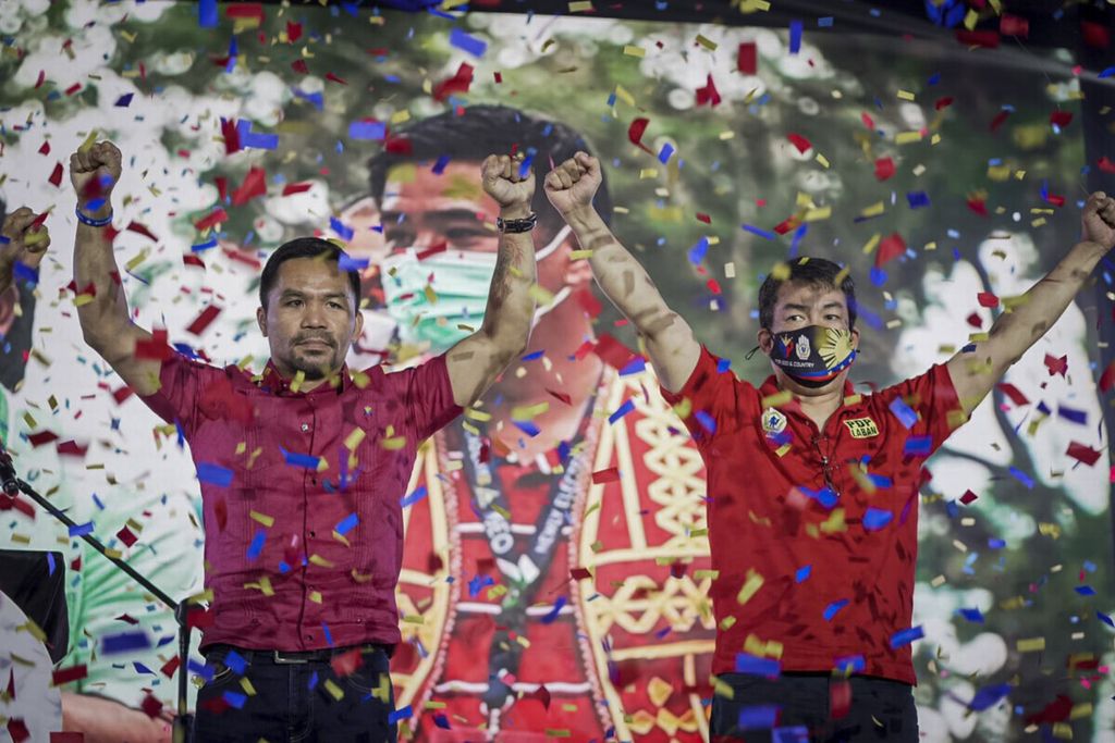 Foto yang diambil pada 19 September 2021 memperlihatkan petinju legendaris Filipina, Manny Pacquiao (kiri), mengangkat kedua tangannya setelah menyatakan siap maju sebagai bakal calon presiden Filipina pada pemilihan tahun 2022. 