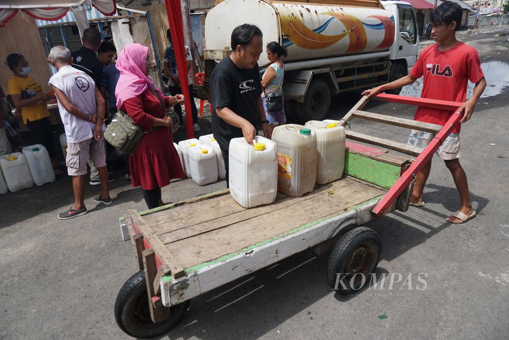 Pedagang memuat jeriken berisi minyak goreng curah ke gerobak dorong di Pasar Bersehati, Kelurahan Calaca, Manado, Sulawesi Utara, Kamis (28/4/2022). 