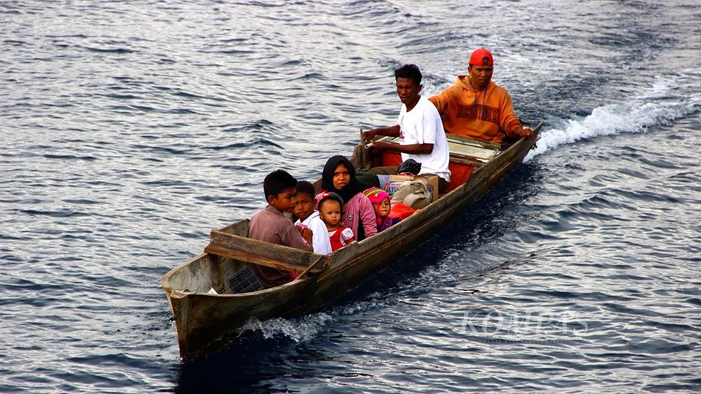 A woman and children take a wooden boat from Obi Island, North Maluku, to reach a ship moored at sea on Monday (9/4/2014). Many villages on the island have no dock.