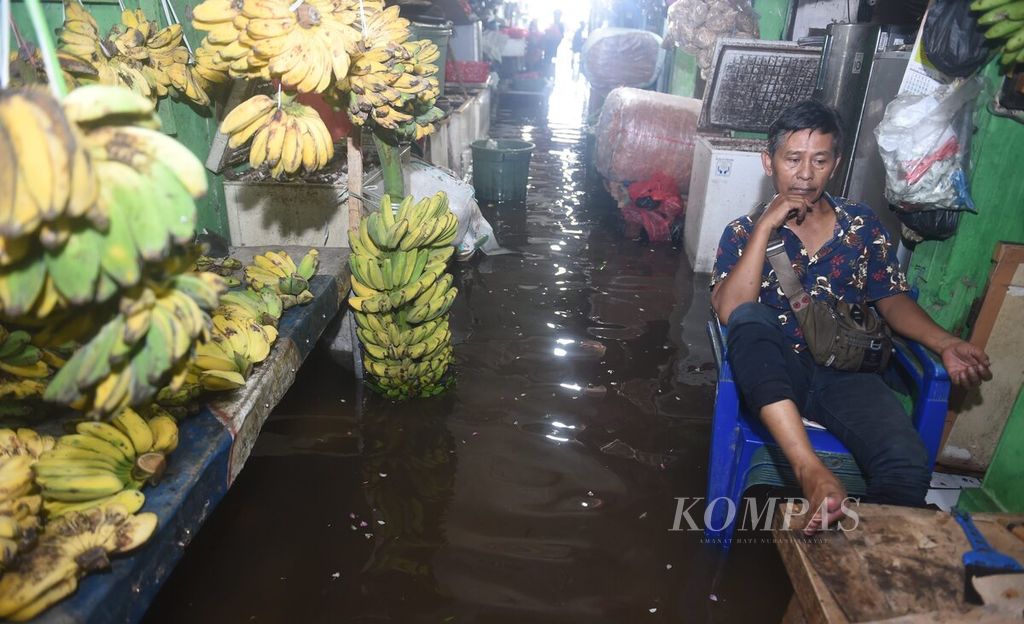 Pedagang pisang menunggu pembeli di Pasar Wadungasri yang tergenang banjir di Kecamatan Waru, Sidoarjo, Rabu (7/2/2024). Banjir di pasar tersebut telah berlangsung selama dua hari. Kejadian tersebut membuat banyak pedagang memilih tidak berjualan. Banjir di Kecamatan Waru berdampak kepada 4.000 keluarga. 