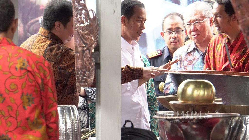 President Joko Widodo  (middle), accompanied by Industry Minister Airlangga Hartarto (left), visits a copper product shop after launching a facility to help small and medium import-export industries (SMIs) in Tumang village, Cepogo district, Boyolali, Central Java, on Monday (30/1/2017). The facility is expected to help boost exports by SMIs.