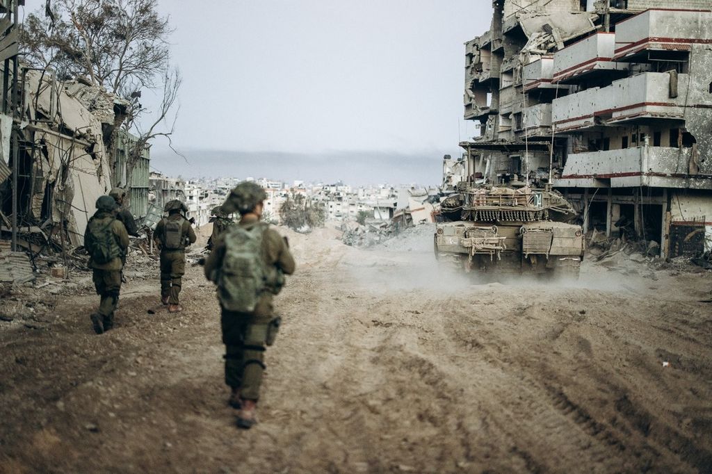 Tentara Israel berjalan di Jalur Gaza, Senin (1/1/2024), di tengah pertempuran melawan kelompok Hamas. 
