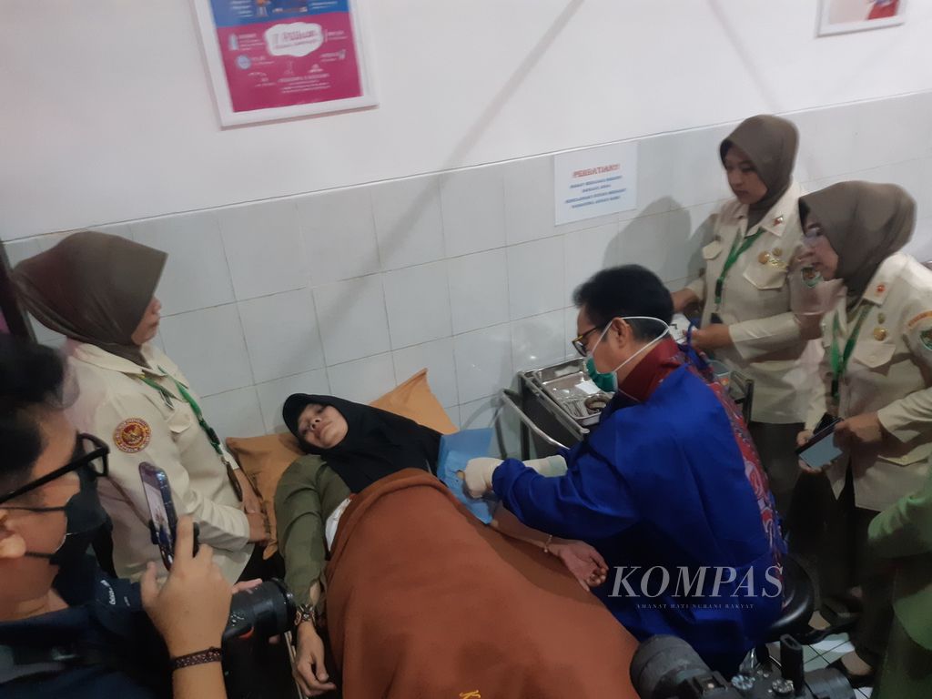 Kepala Badan Kependudukan dan Keluarga Berencana Nasional (BKKBN) Hasto Wardoyo memasang alat kontrasepsi implan di tangan salah seorang ibu di Klinik Siliwangi, Kota Cimahi, Jawa Barat, Senin (23/10/2023).