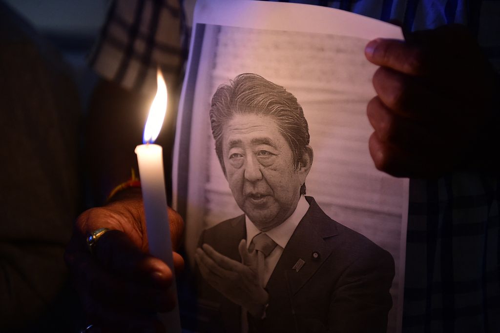 Anggota pusat studi dan informasi Jepang memegang lilin untuk menghormati mendiang Perdana Menteri Jepang Shinzo Abe di Ahmedabad Management Association di Ahmedabad, India, 9 Juli 2022. 