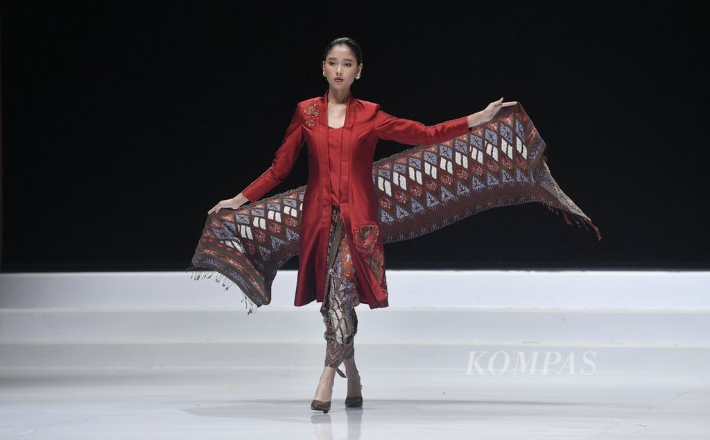 Model membawakan busana koleksi Poppy Dharsono x Pemerintah Kabupaten Garut yang mengangkat kreasi dari tenun sutra dan batik Garutan dalam Indonesia Fashion Week (IFW) 2023 di Jakarta Convention Center, Jakarta. 